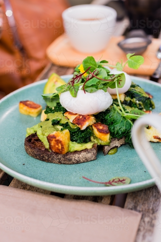 poached eggs with halloumi, avo and rye bread - Australian Stock Image