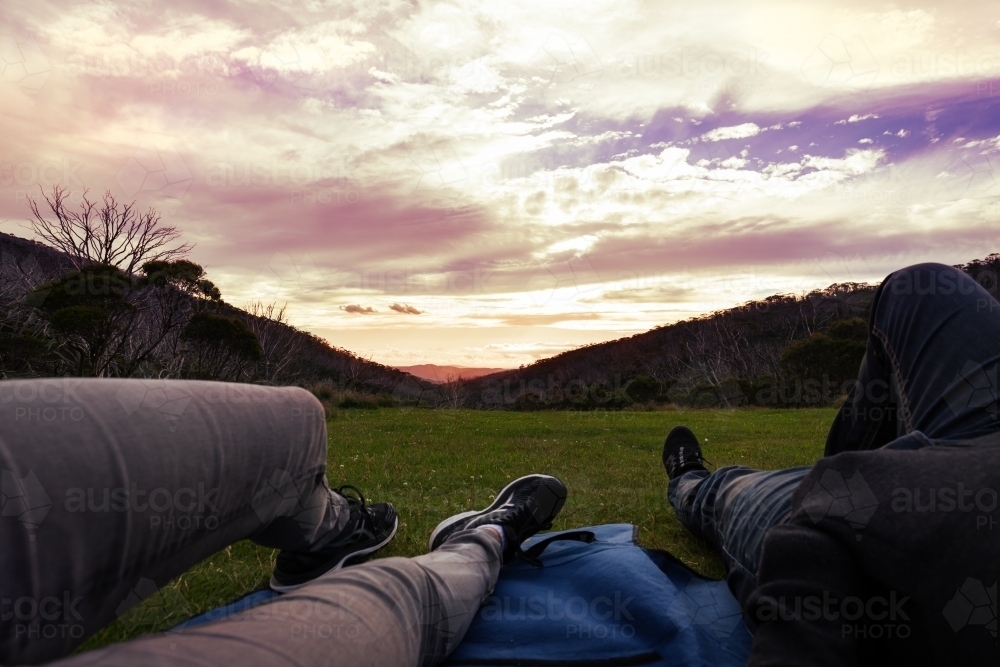 Point of view of couple lying on a rug watching the sunset - Australian Stock Image