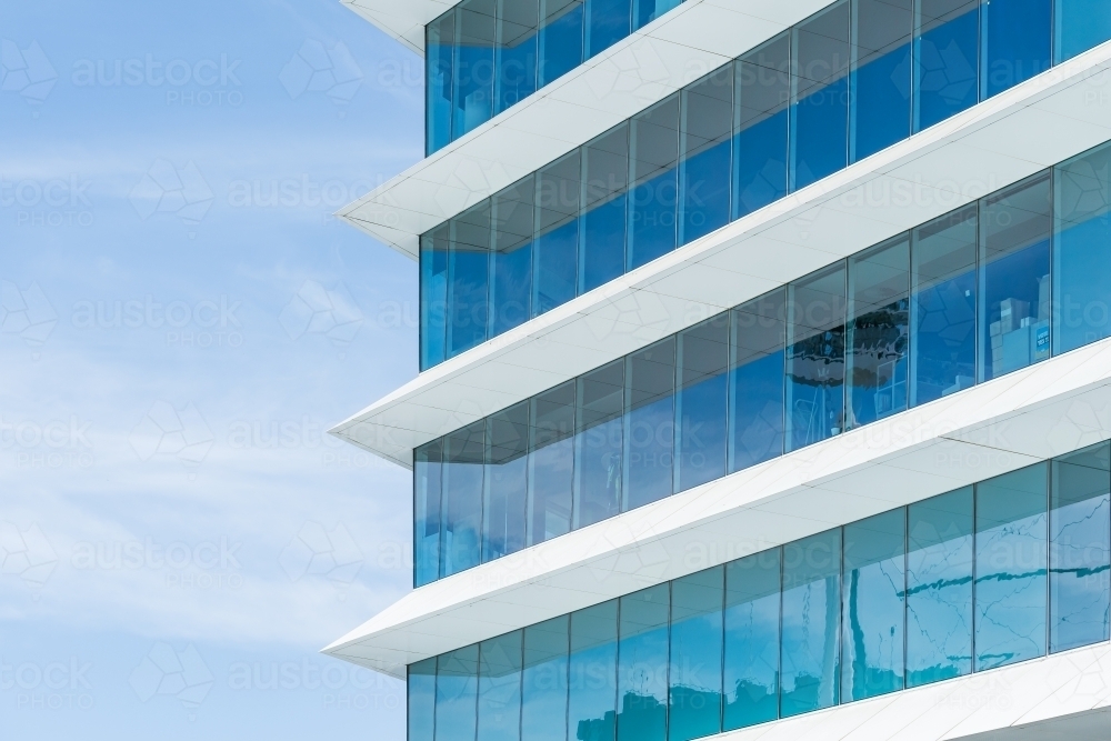 Pointed cement protrusions between glass windows of a modern high rise building - Australian Stock Image