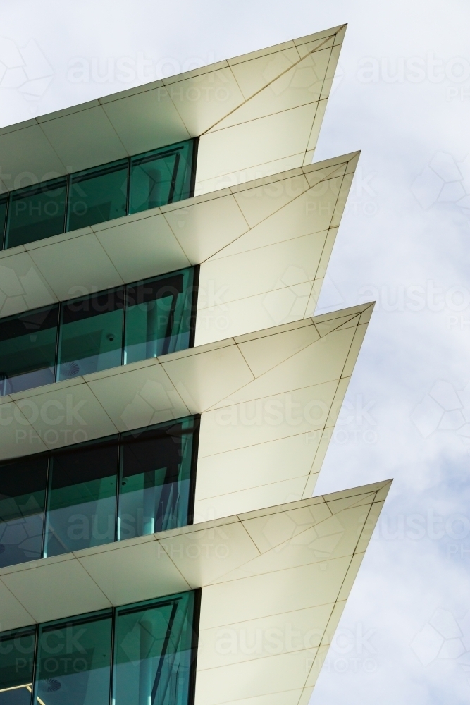 Pointed cement protrusions between glass windows of a modern high rise building - Australian Stock Image