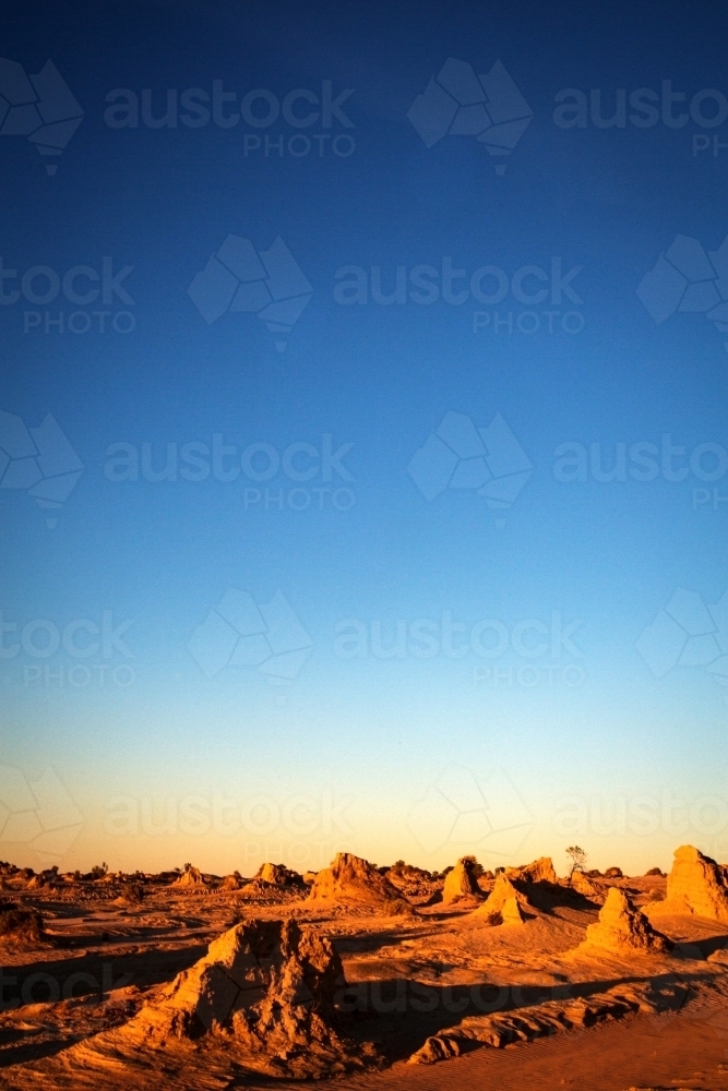 pointy rocks on the ground with sand with blue skies - Australian Stock Image