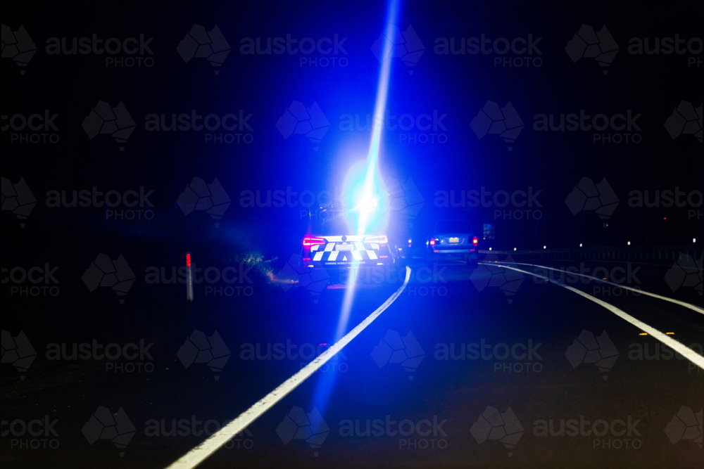 Image of police cars blue light shining from parking place on roadside ...