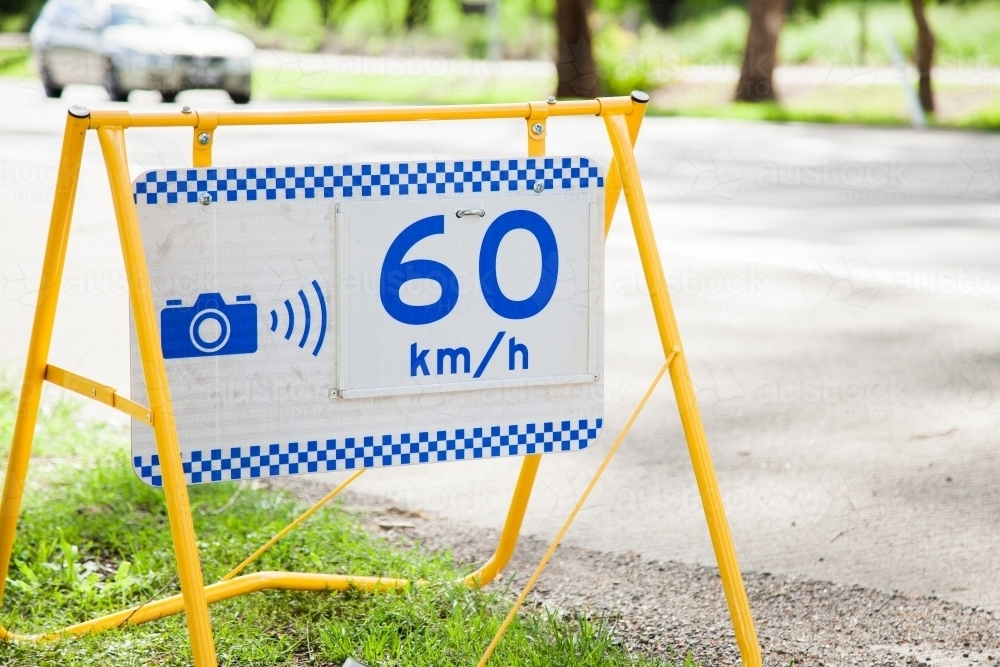 Police speed camera 60 km speed zone sign beside highway - Australian Stock Image