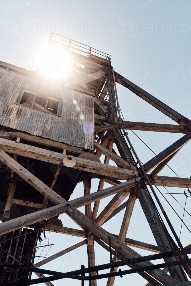 Poppet Head shaft of former mine in Broken Hill with sunburst - Australian Stock Image