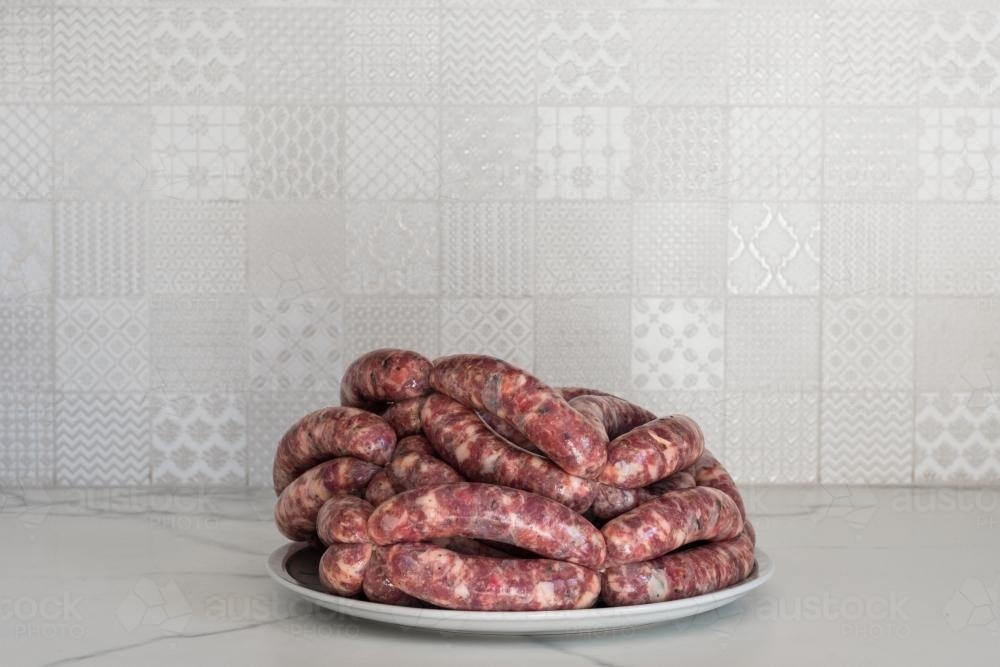 Pork and fennel raw sausages on a plate - Australian Stock Image