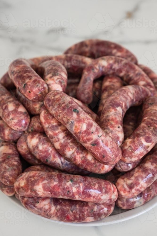 Pork and fennel raw sausages on a plate - Australian Stock Image