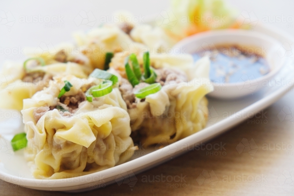 Pork dumpling; dim sum on white plate - Australian Stock Image