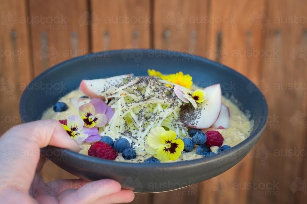 Porridge with fruit and edible flowers - Australian Stock Image