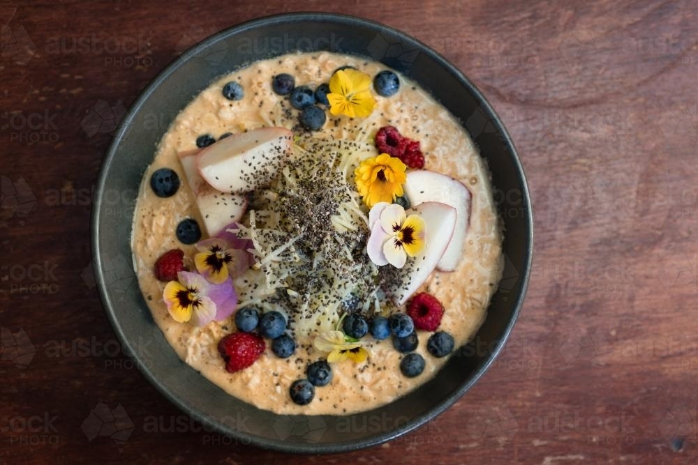 Porridge with fruit and edible flowers - Australian Stock Image