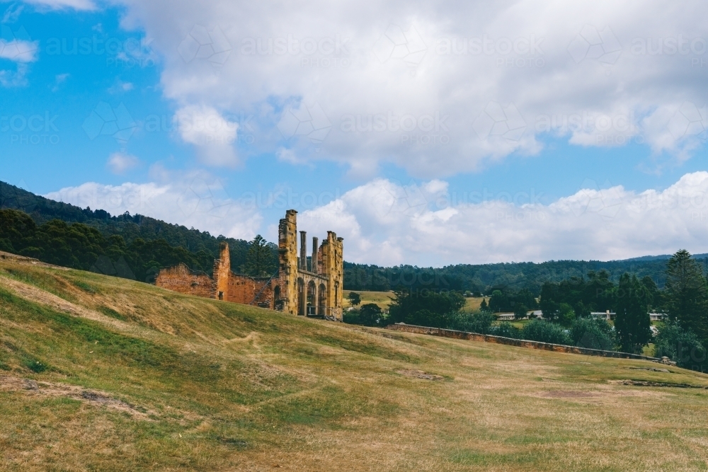 Port Arthur scenic, empty land where houses once stood, with ruins in the background - Australian Stock Image