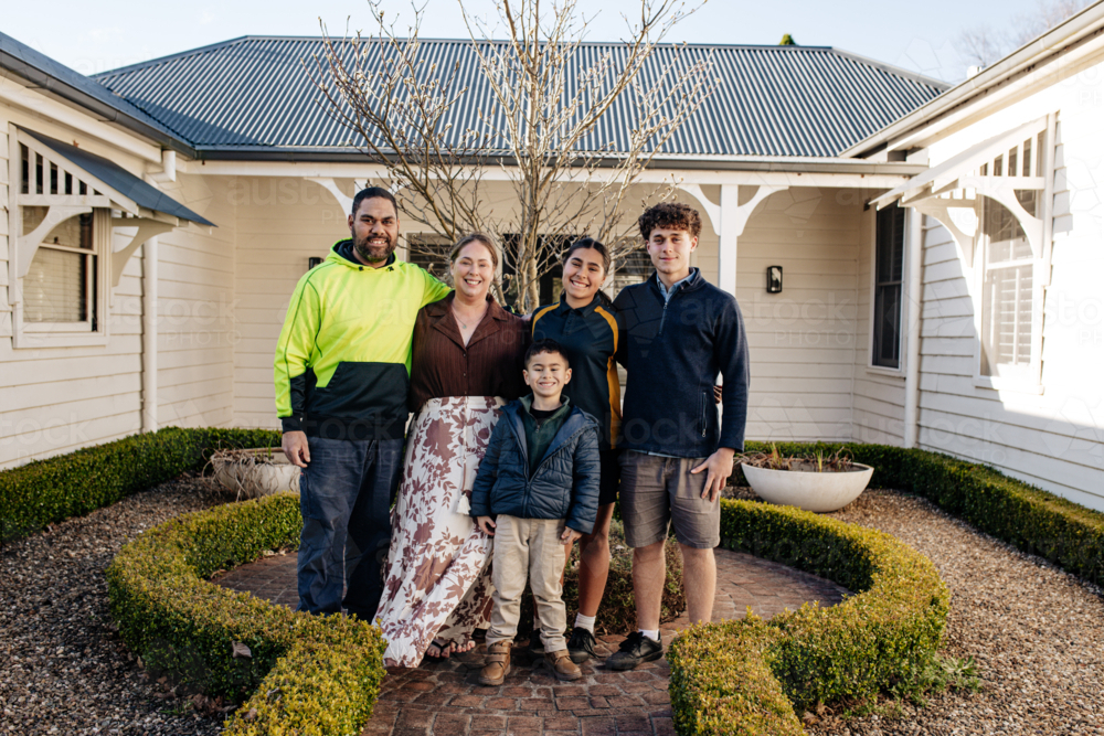 Portrait if a family with mixed ethnicity outside home - Australian Stock Image