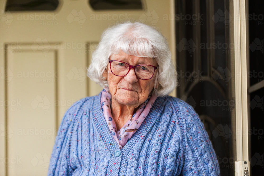 Portrait of 99 year old elderly Australian woman standing by front door of her home - Australian Stock Image