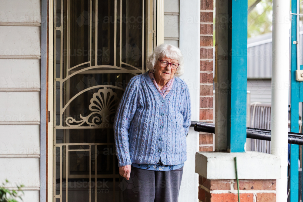 Portrait of 99 year old elderly Australian woman standing by front door of her home - Australian Stock Image