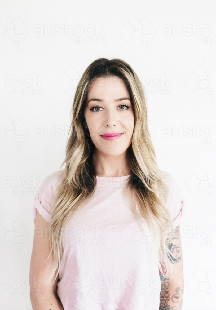 Portrait of a blonde girl with natural style makeup and pink lipstick on white background - Australian Stock Image