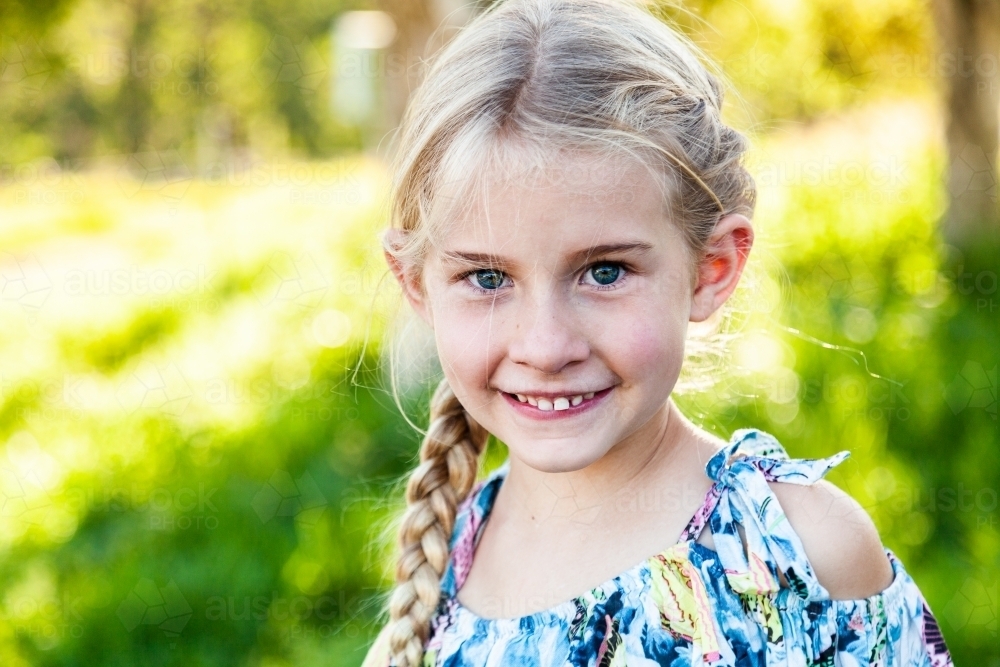 portrait of a blue eyes blond young girl outside - Australian Stock Image