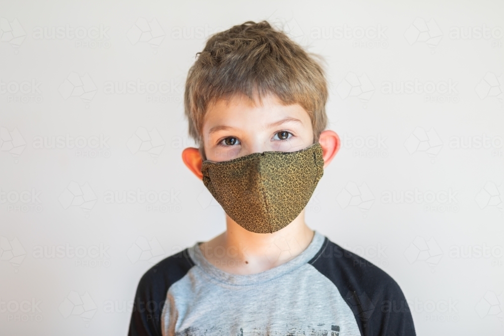 portrait of a boy wearing a re-usable facemask - Australian Stock Image