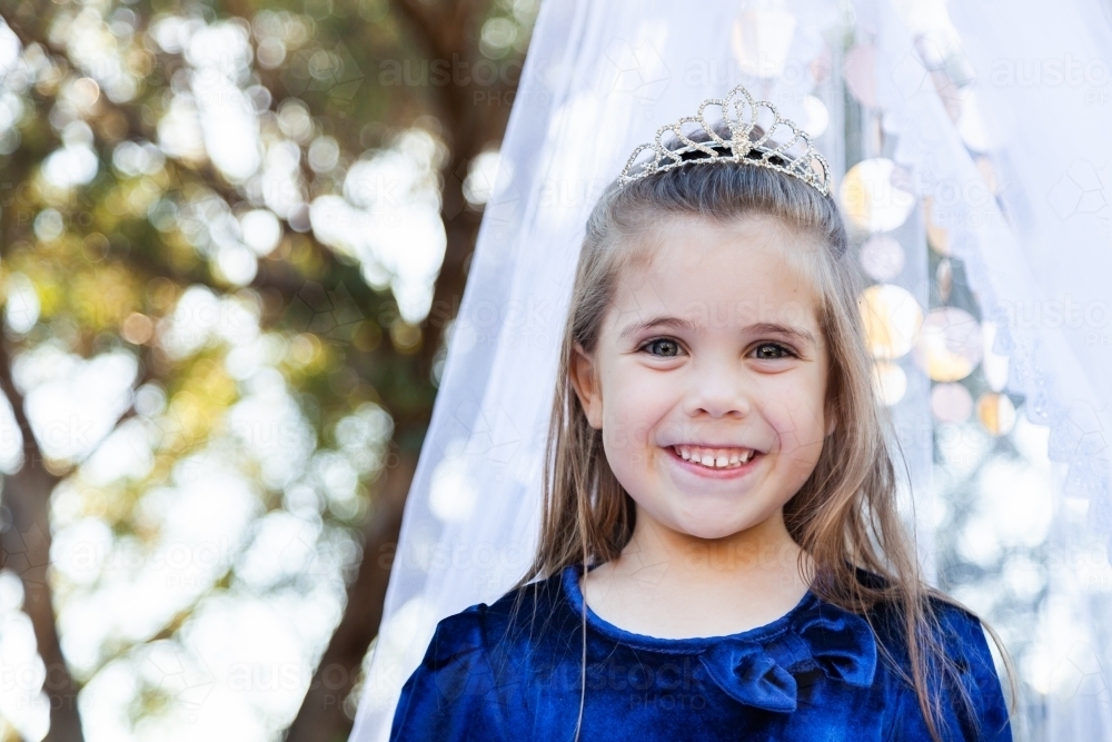 Portrait of a child playing dress ups as a princess with a silver tiara - Australian Stock Image