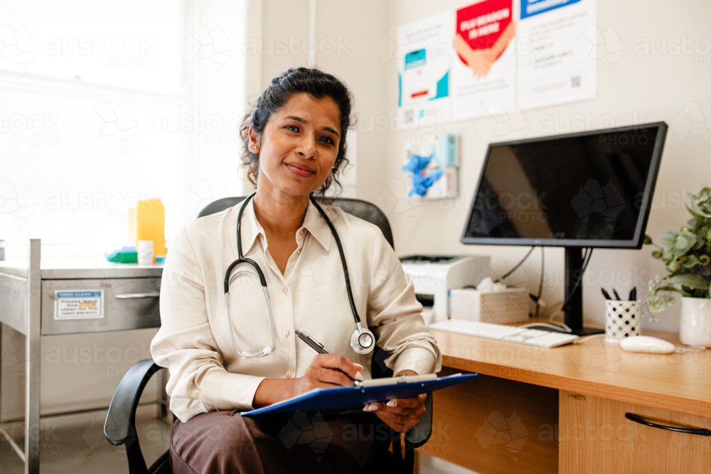 Portrait of a female healthcare professional writing notes in medical office - Australian Stock Image