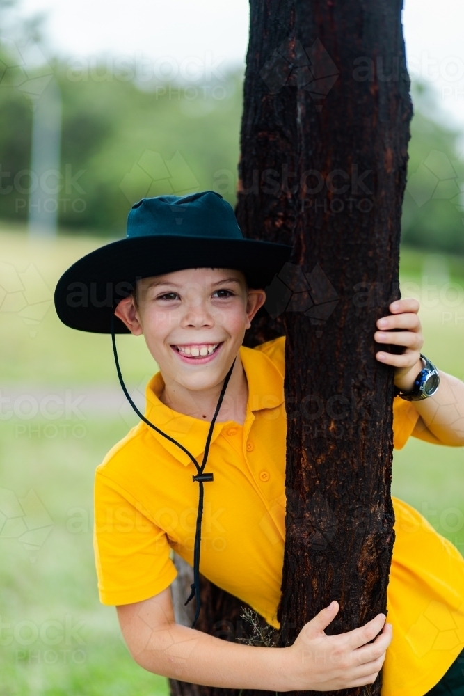Portrait of a happy aussie school boy outside with a hat on - Australian Stock Image