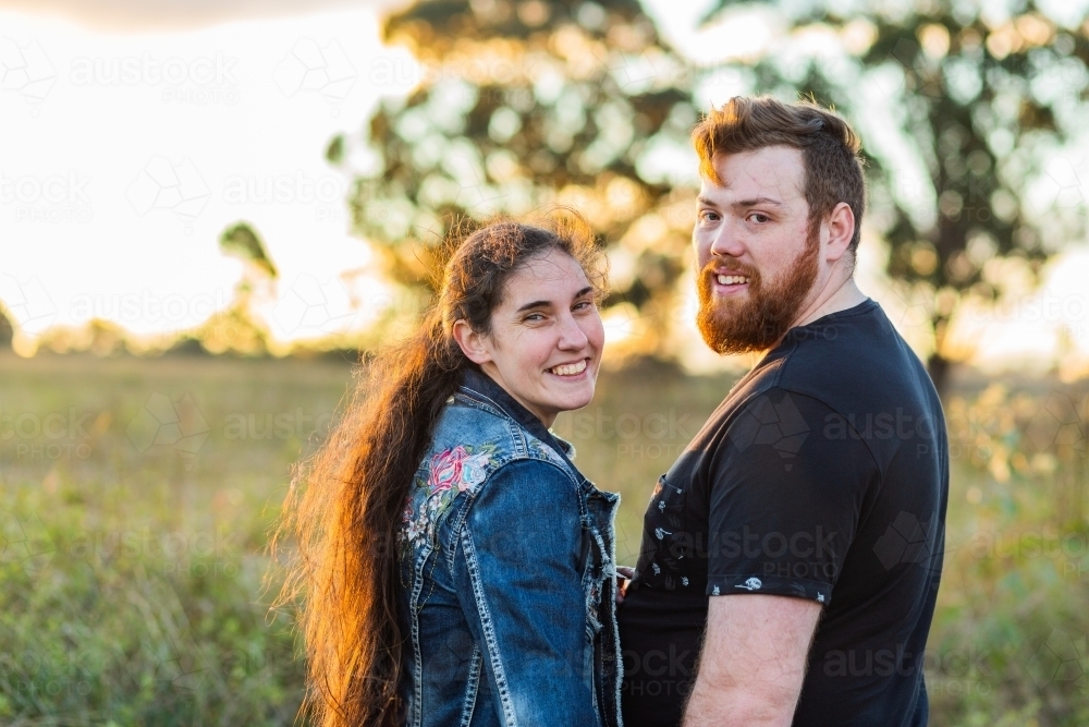 Image of Portrait of a happy australian couple outdoors in sunset light