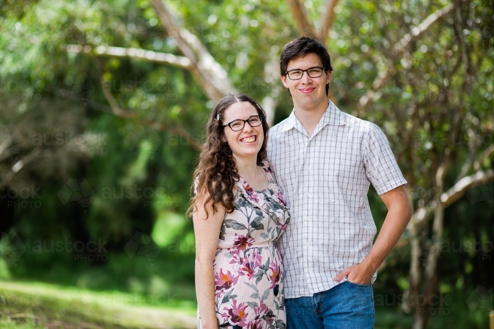 Portrait of a happy couple standing outside in the shade - Australian Stock Image