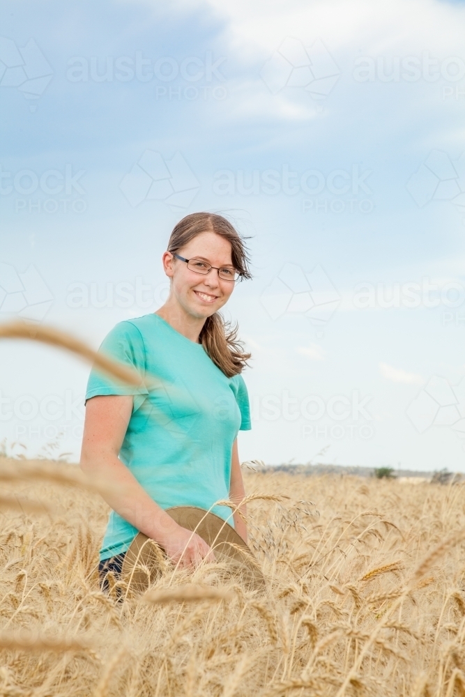 Portrait of a happy kid in paddock of bearded wheat crop on a farm - Australian Stock Image