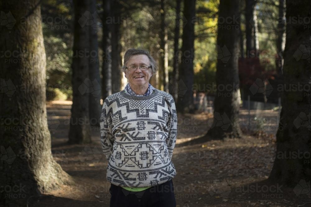 Portrait of a happy man among huge trees in the park - Australian Stock Image