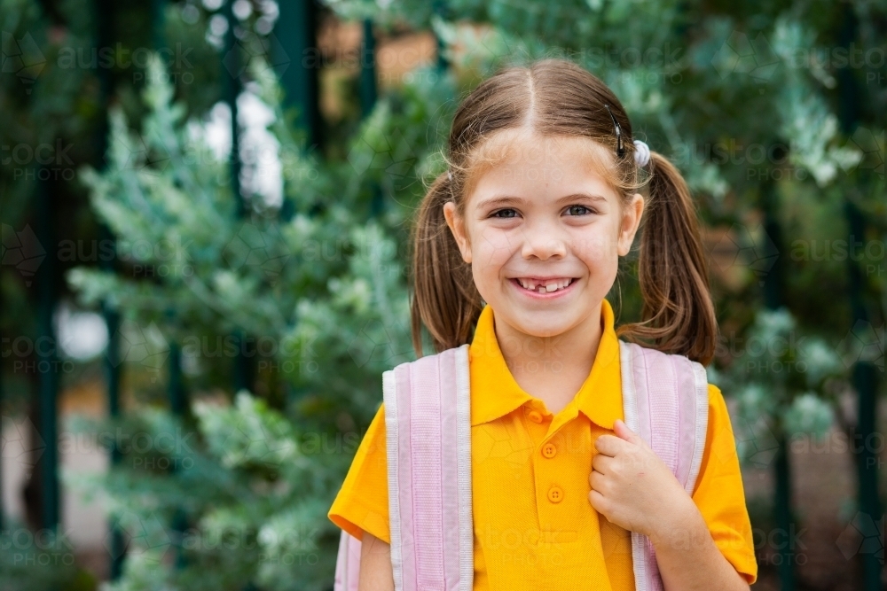 Portrait of a happy school girl with her bag on ready to go back to school - Australian Stock Image