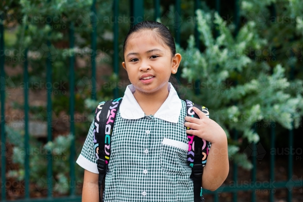 Portrait of a happy school girl with her bag on ready to go back to school - Australian Stock Image