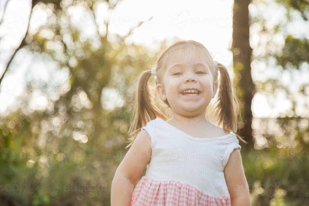 Portrait of a happy smiling child outside in the garden - Australian Stock Image