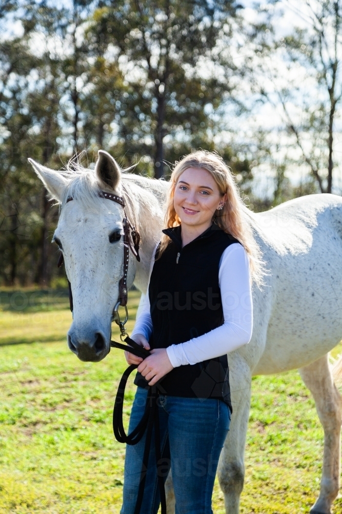 Portrait of a happy smiling young aussie woman and her horse - Australian Stock Image
