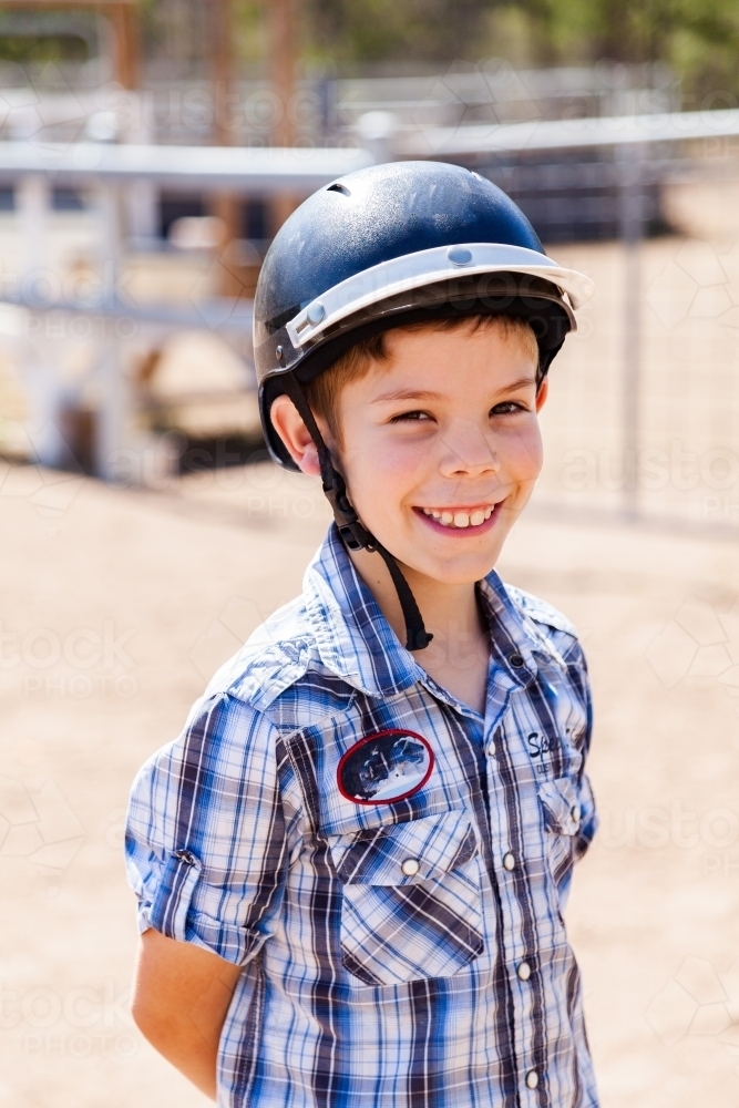 Portrait of a happy young boy in a horse riding helmet - Australian Stock Image