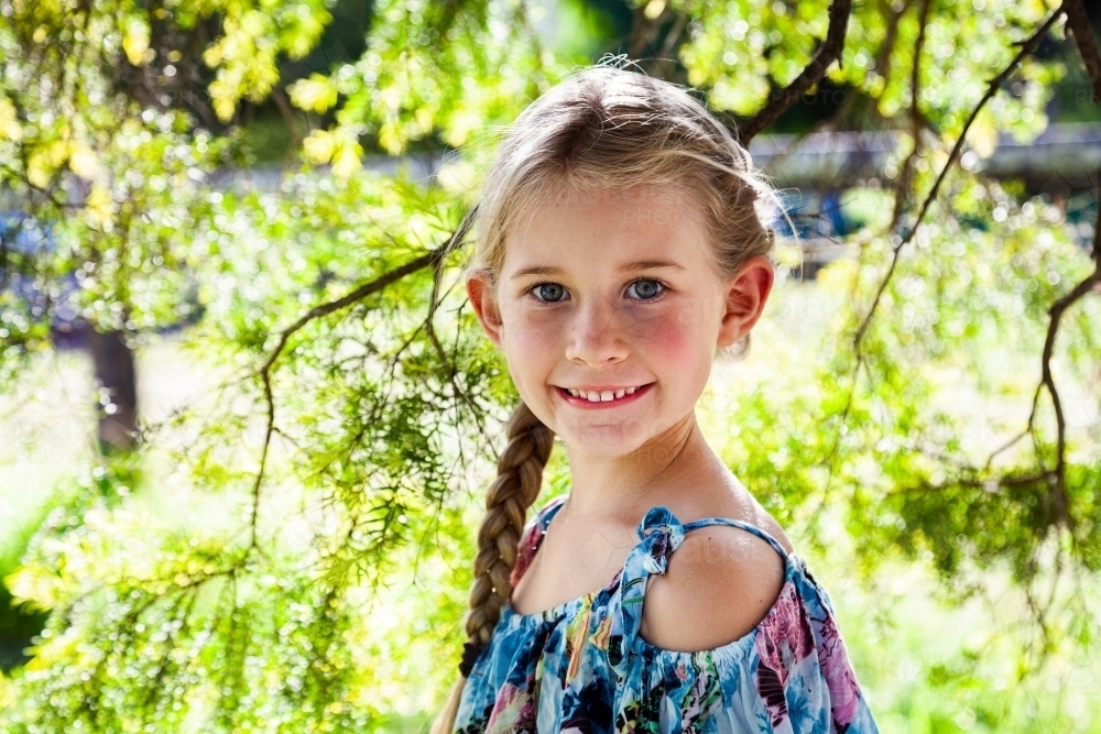 Portrait of a happy young girl with blonde hair outside - Australian Stock Image