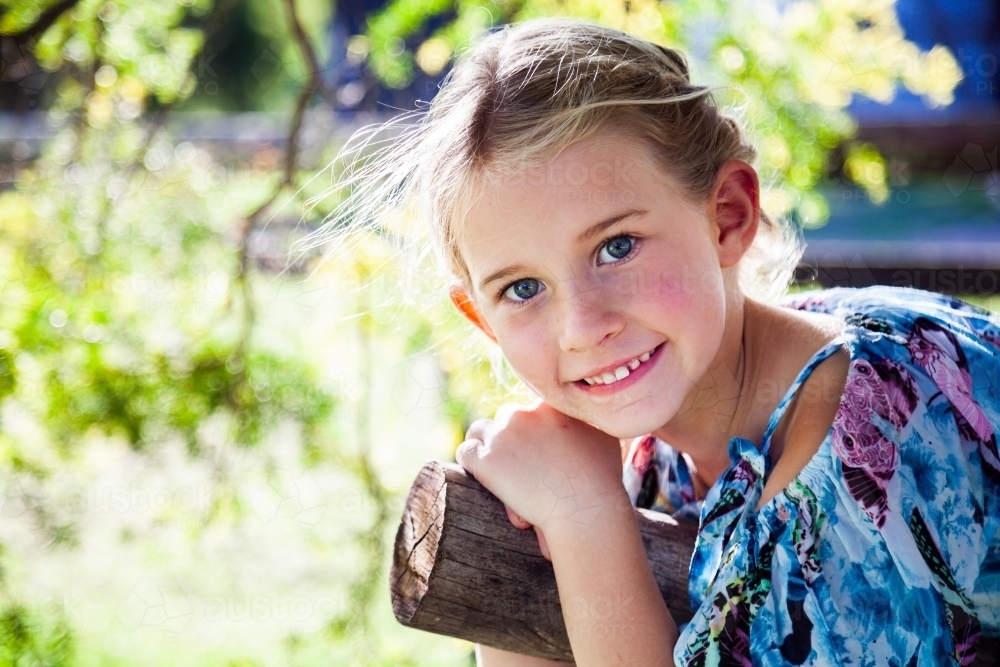 Portrait of a happy young girl with blonde hair outside - Australian Stock Image