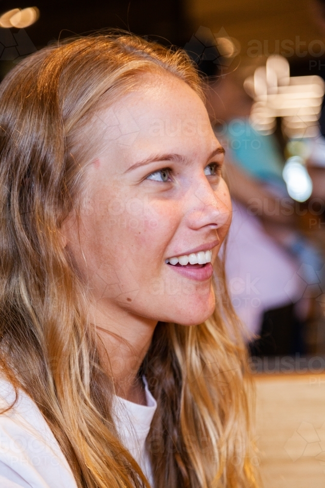 Portrait of a happy young woman engaged in a conversation - Australian Stock Image