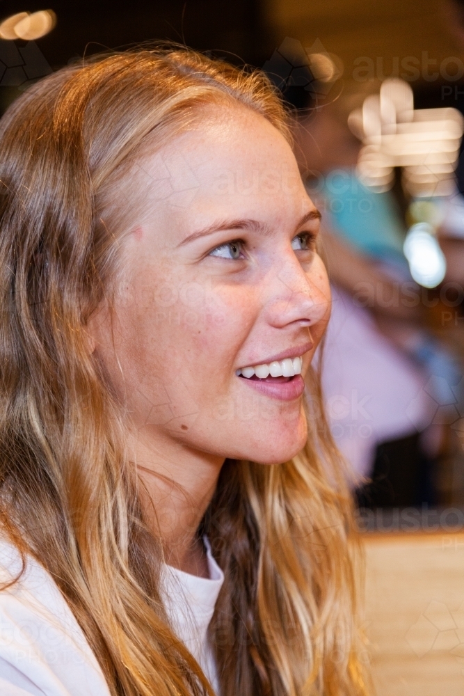 Portrait of a happy young woman looking off camera talking - Australian Stock Image