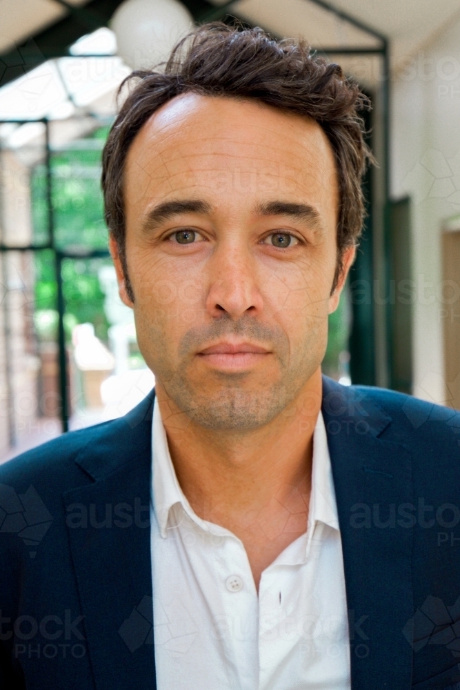 Portrait of a male office worker standing near the exit of the building - Australian Stock Image