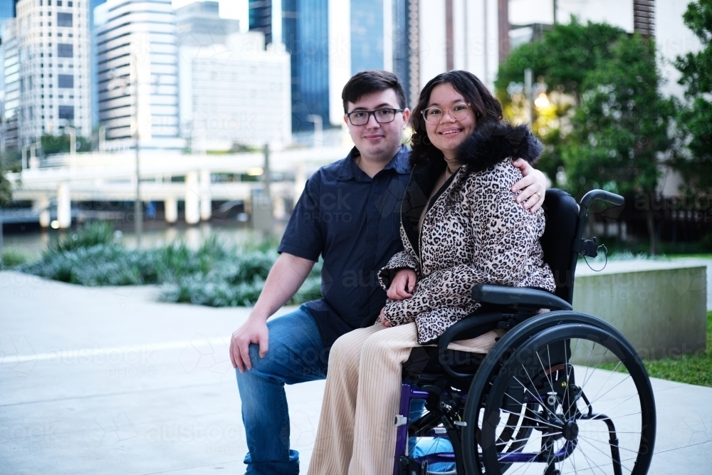 Portrait of a man a woman with a disability in wheel chair sitting outside - Australian Stock Image