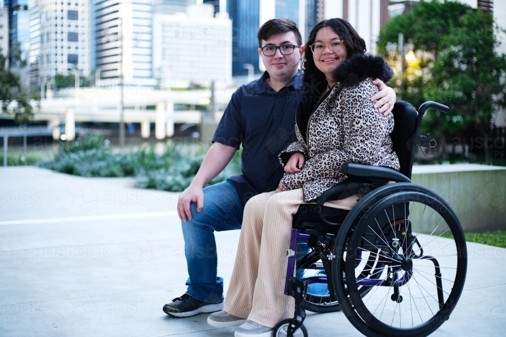 Portrait of a man a woman with a disability in wheel chair sitting outside - Australian Stock Image