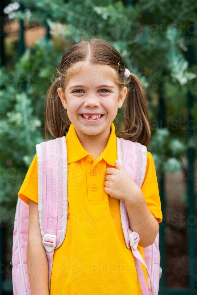 Portrait of a smiling young Australian school girl with bag ready to go back to school - Australian Stock Image