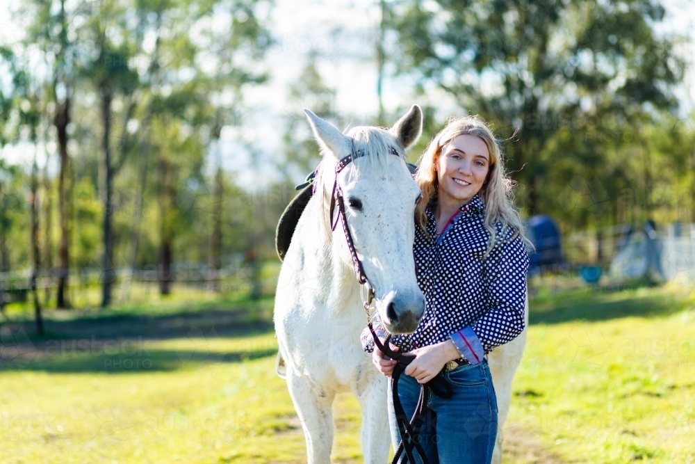 Portrait of a teen horserider in paddock with her horse and copy space - Australian Stock Image