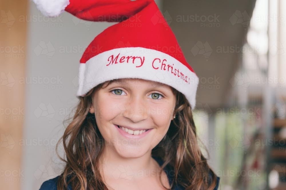 portrait of a tween girl wearing a christmas hat - Australian Stock Image