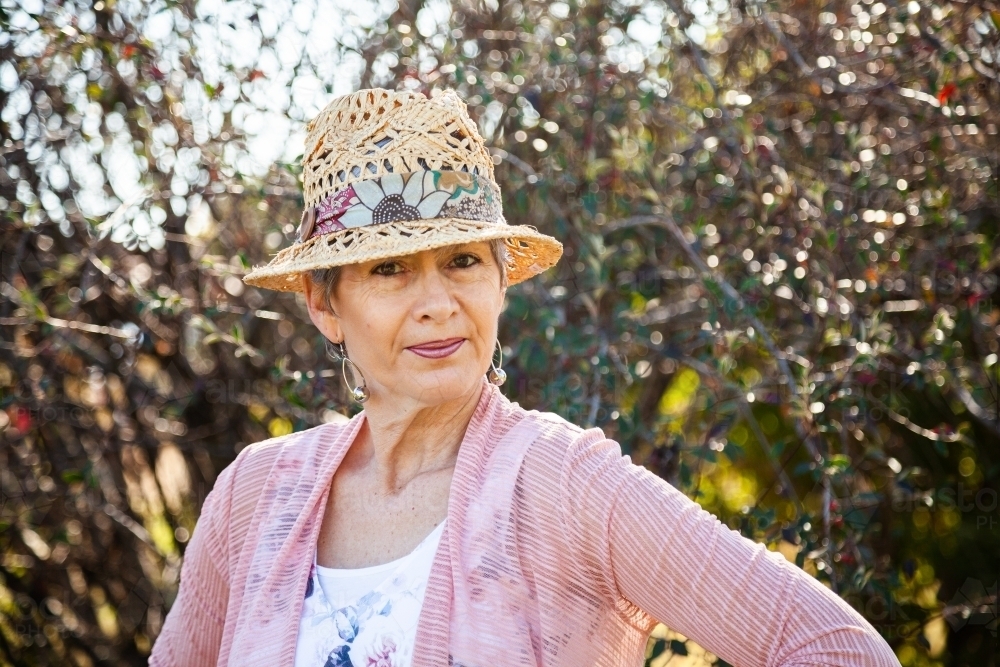 Portrait of a woman in a hat in the garden - Australian Stock Image