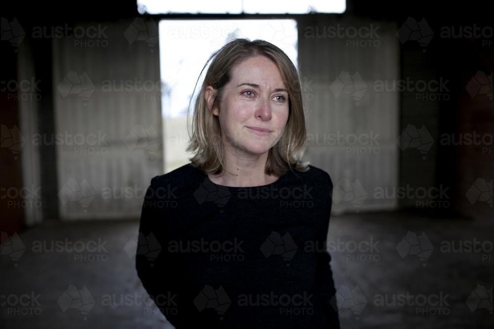 Portrait of a woman with background of a dimly lit shed - Australian Stock Image