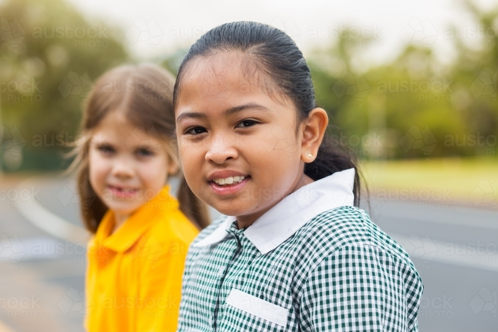 Portrait of a young Australian girl of Filipino ethnicity sitting outside school - Australian Stock Image