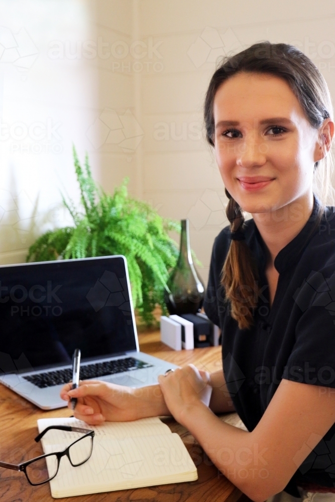 Portrait of a young creative female worker at her office desk - Australian Stock Image