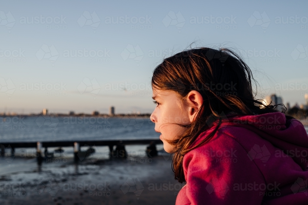 Portrait of a young girl at St Kilda beach at sunset, Melbourne, Australia - Australian Stock Image