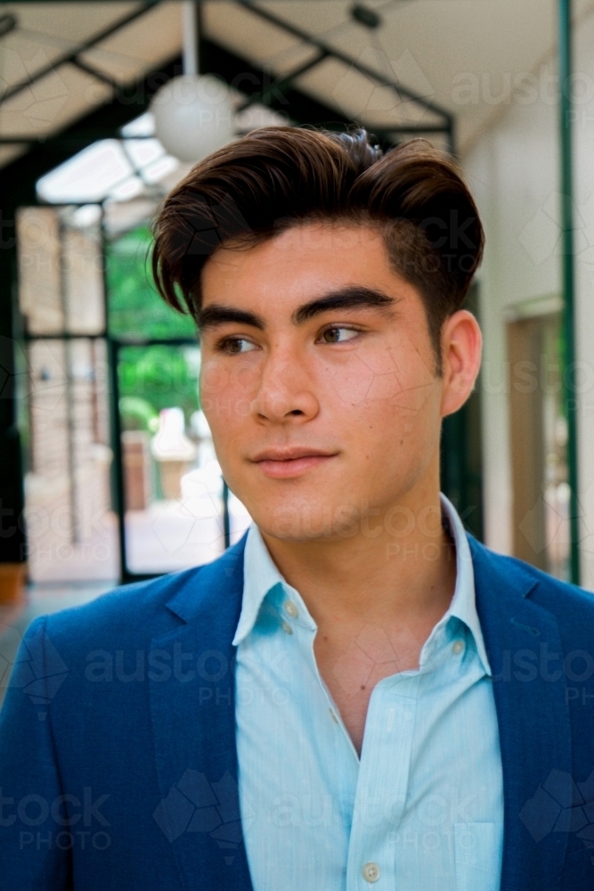 Portrait of a young male office worker standing near the exit of the building - Australian Stock Image