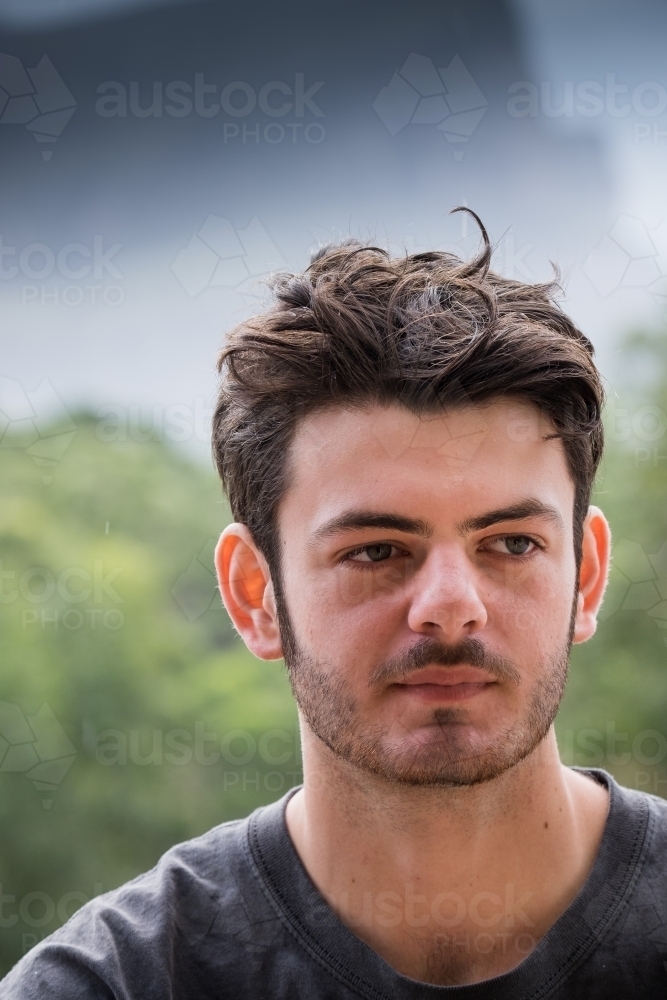 Portrait of a young man with a mountain range in the background - Australian Stock Image