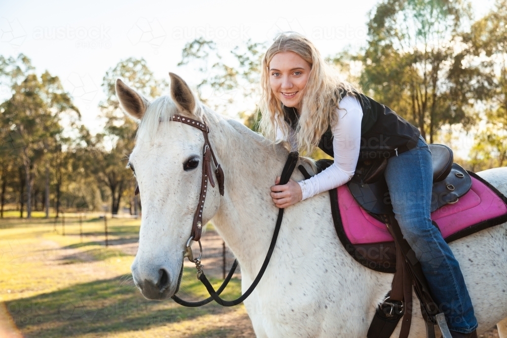 Portrait of a young smiling horserider on her pet horse - Australian Stock Image